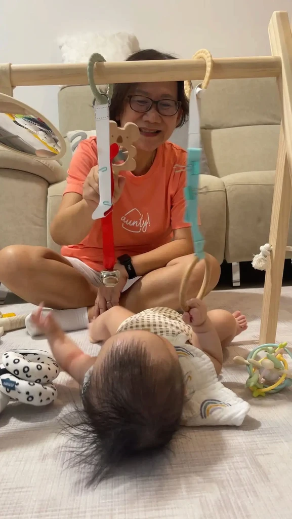 Aunty babysitter playing with baby using activity gym