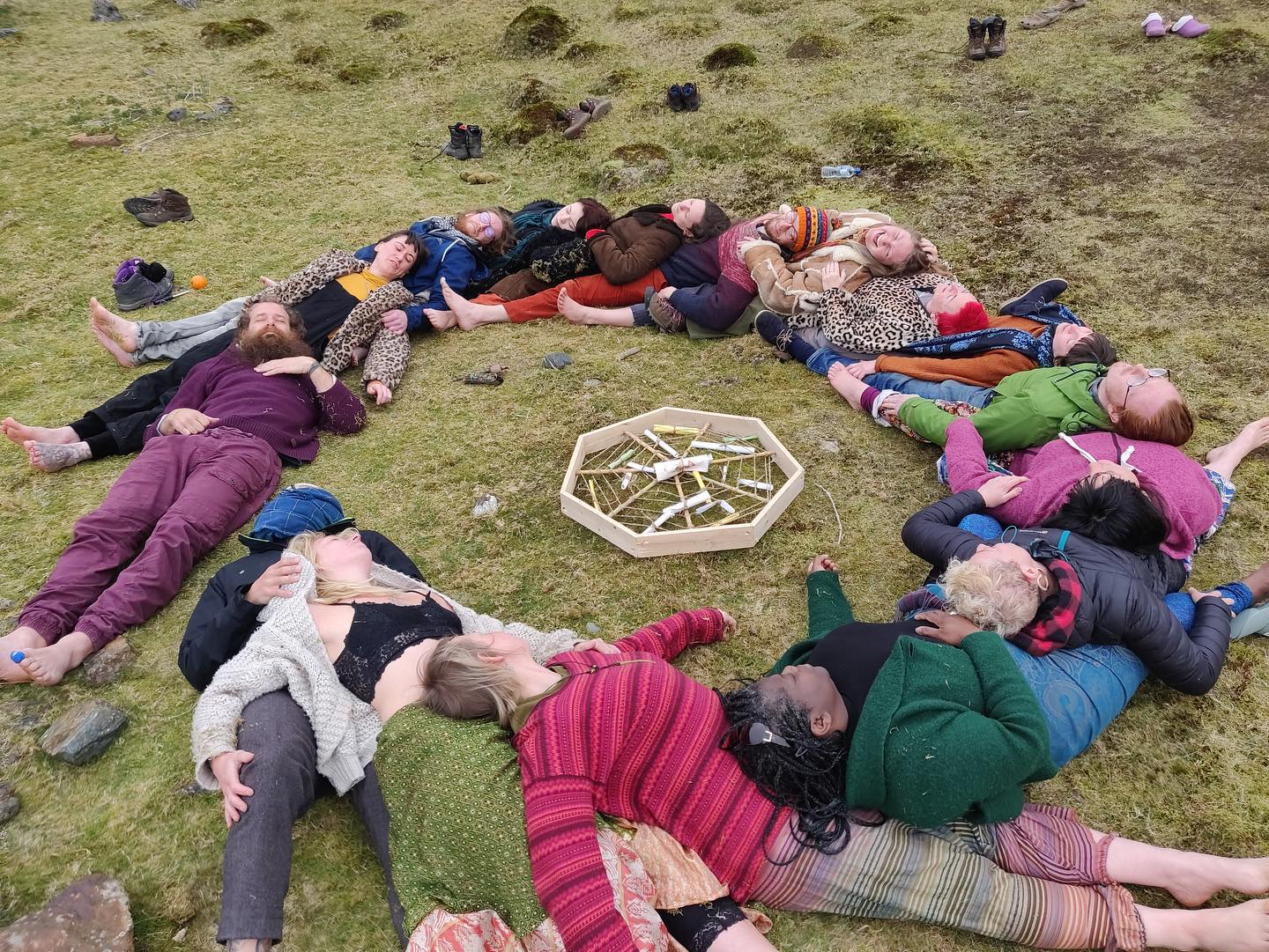 A man with glasses and a beard is looking directly at the camera, seated in a cozy, dimly lit café.