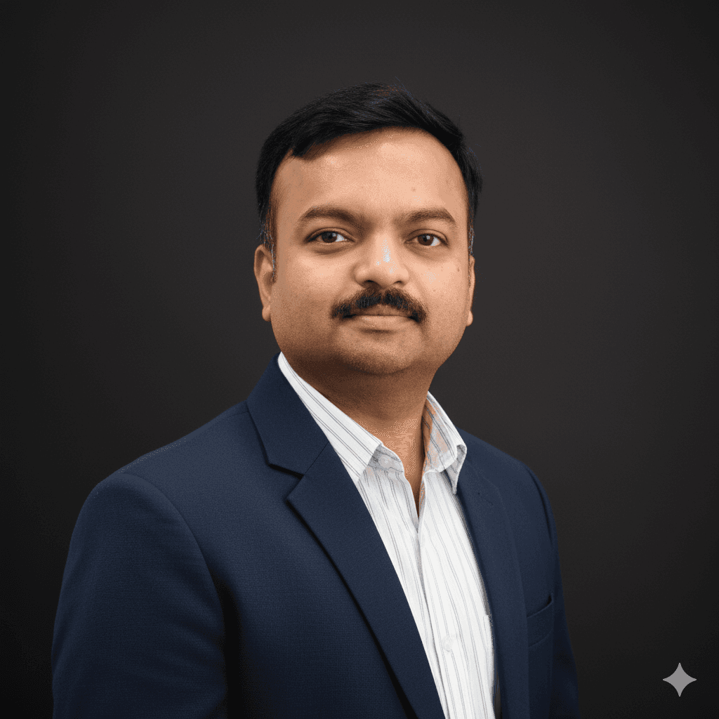 Young man with wavy hair wears a dark overcoat, rust-colored sweater, white shirt, and patterned tie, exuding a poised and sophisticated demeanor.