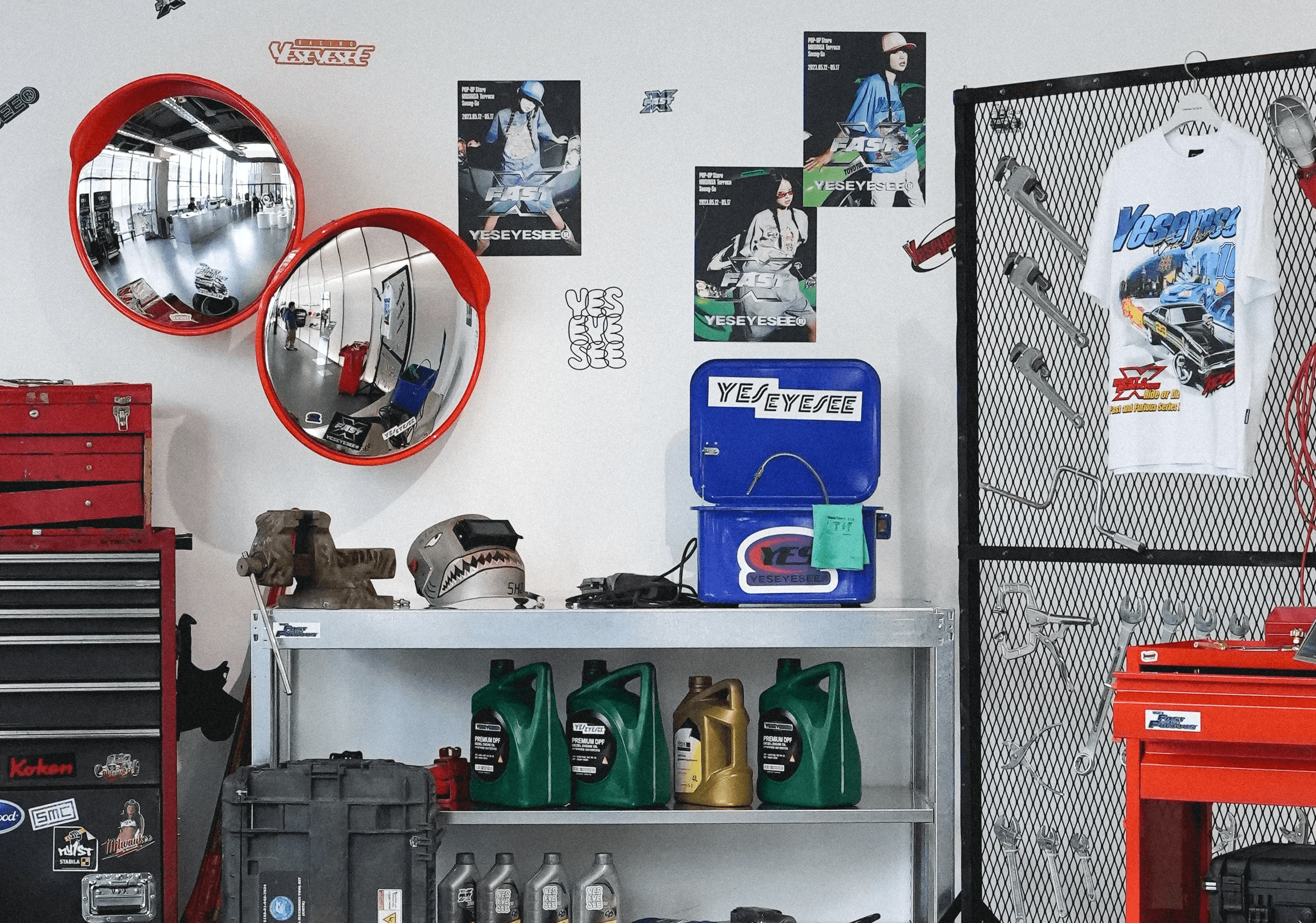 YESEYESEE 팝업 VMD 핵심 오브제 클로즈업, 빨간 볼록 거울과 스티커 공구함 / Close-up of key VMD objects at the YESEYESEE pop-up — red convex mirrors and sticker-covered tool chest
