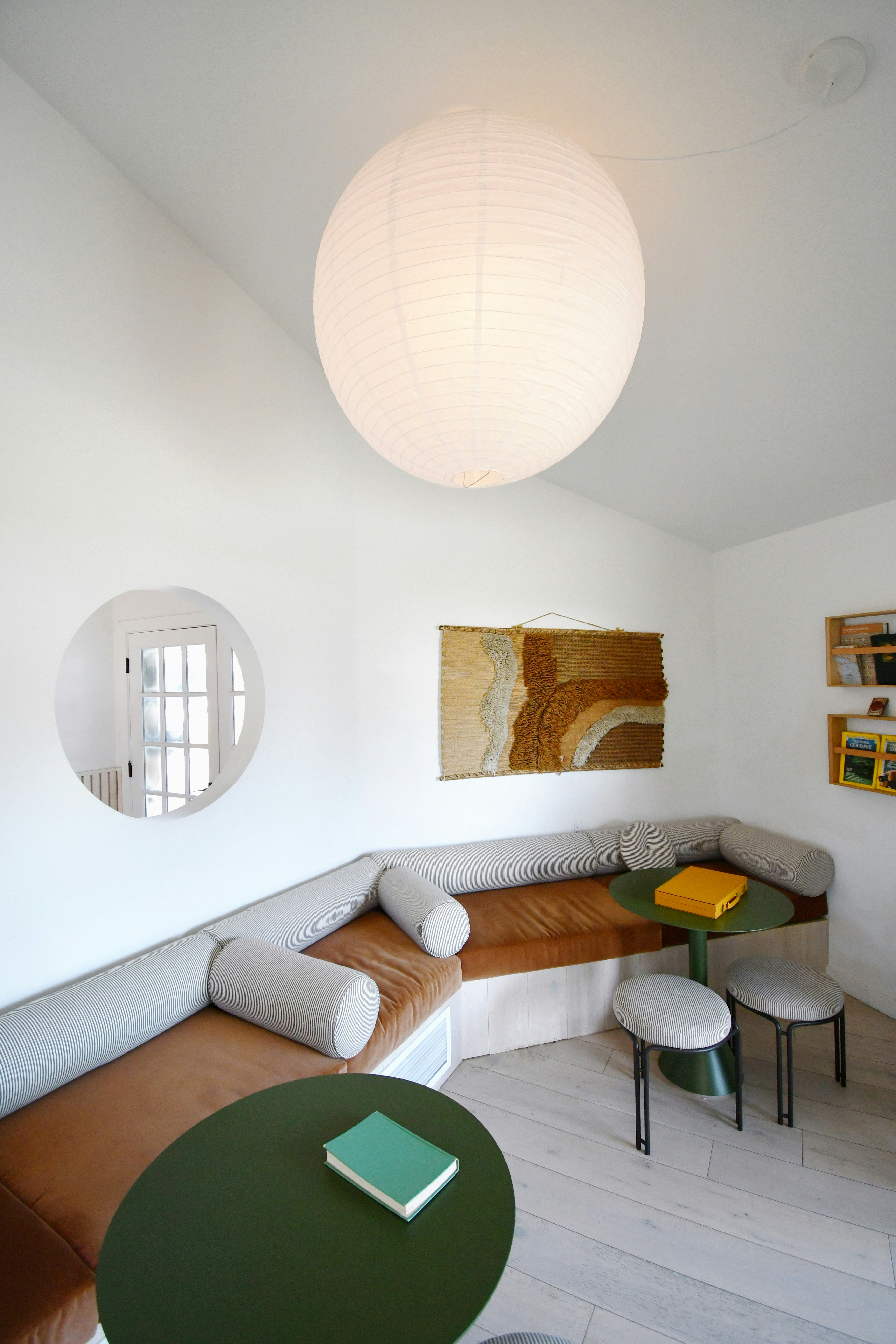 Modern living room with a round mirror and comfortable seating.