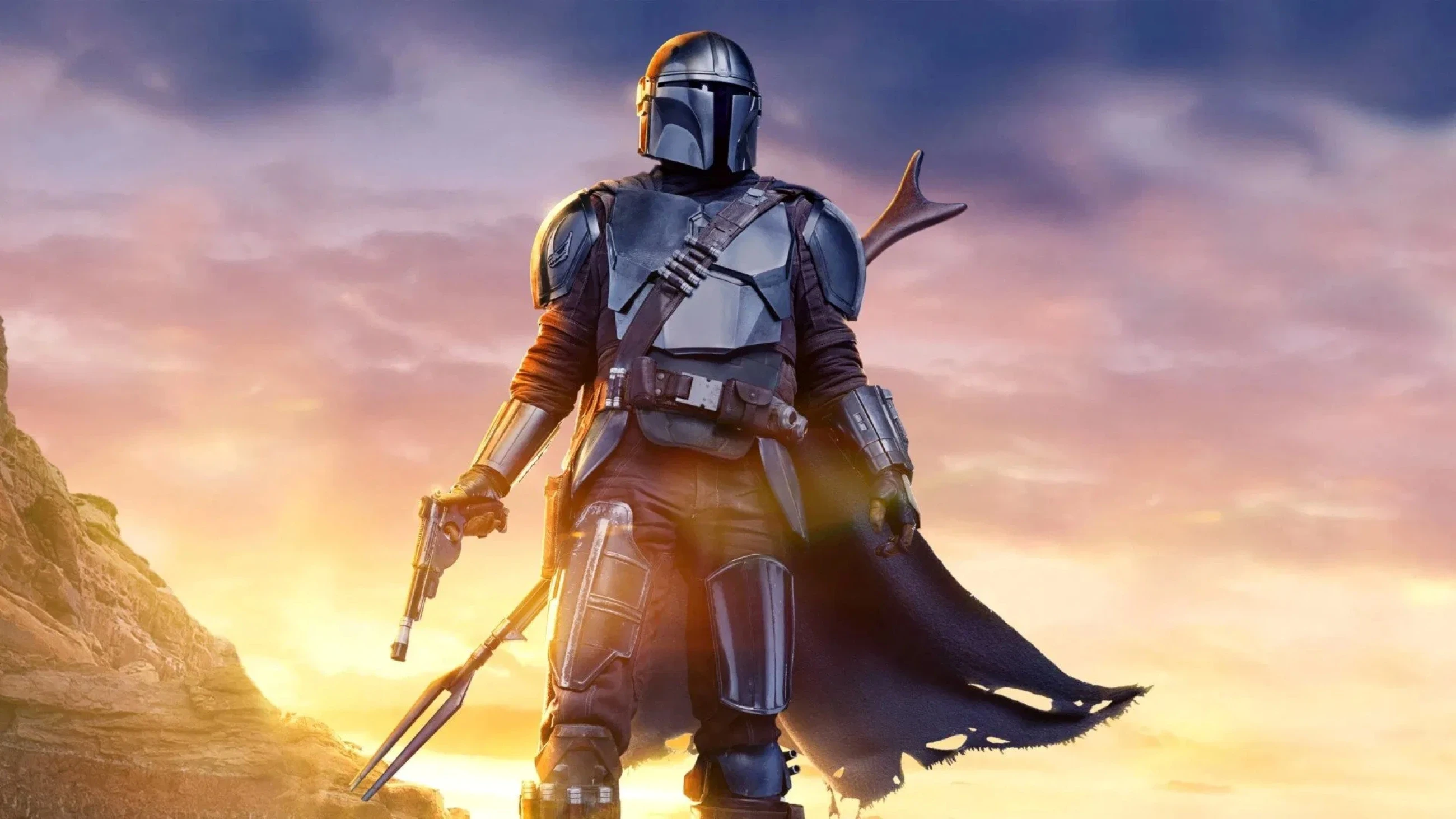 A figure wearing futuristic armour and a helmet stands against a dramatic sunset backdrop, holding a weapon in one hand, exuding bravery and mystery in a sci-fi landscape.