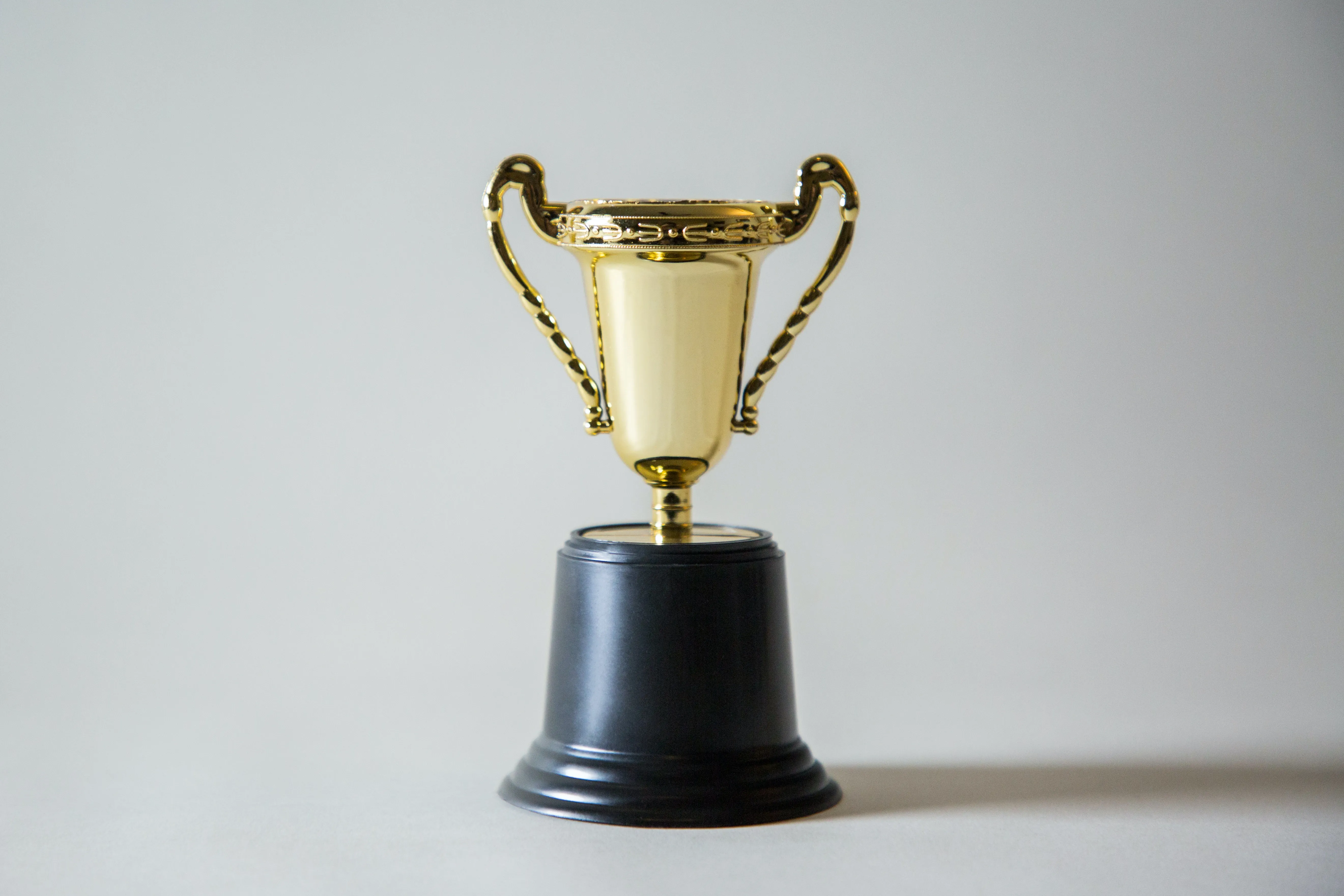 Gold trophy with black base against a gray background