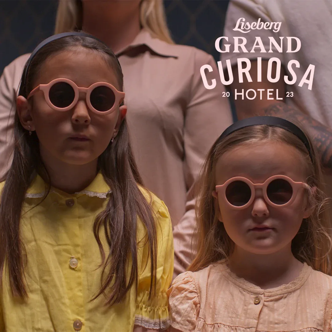 Två flickor med runda rosa solglasögon, med texten Liseberg Grand Curiosa Hotel 2023
