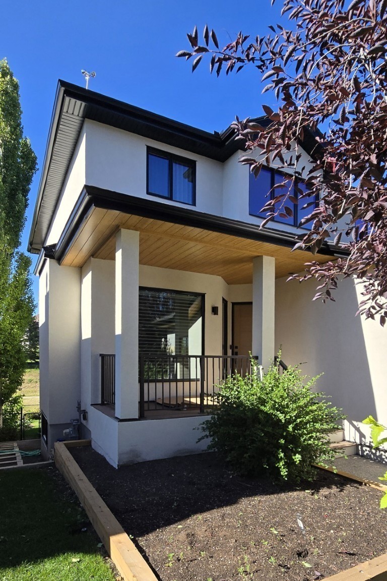 Image of KHD Homes modern white two-story house with black trim and covered porch exterior design and construction.