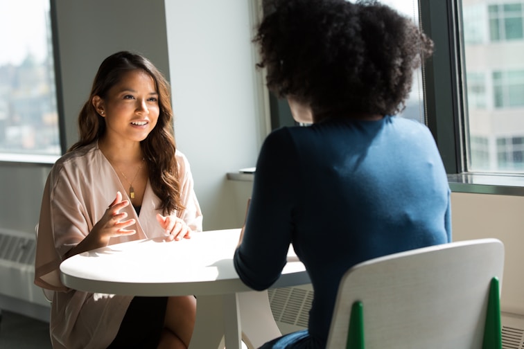 Two ladies across each other on a table