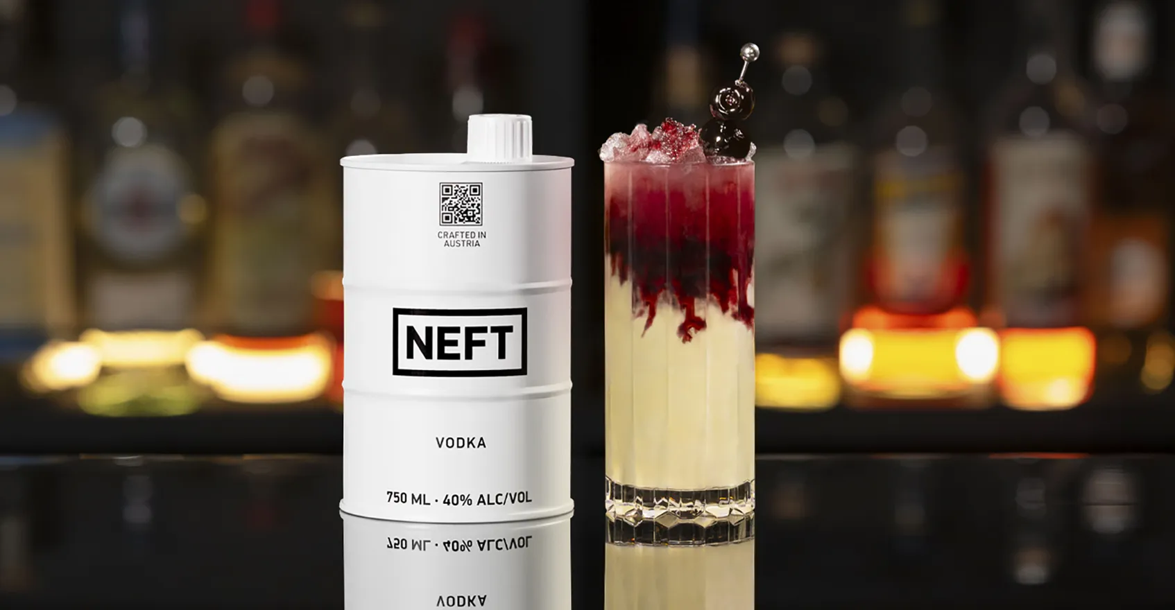 A NEFT Barrel and a glass of Smashed Ice Daiquiri on a bar counter.