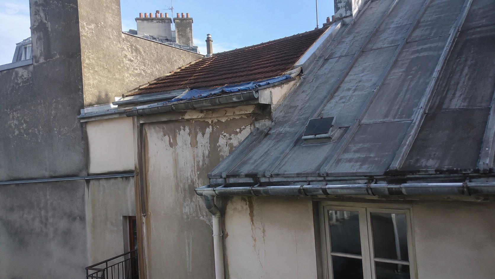 Fuite de toiture sur immeuble parisien avec traces d’infiltration, illustrant la convention IRSI et la question de la prise en charge des dégâts des eaux.