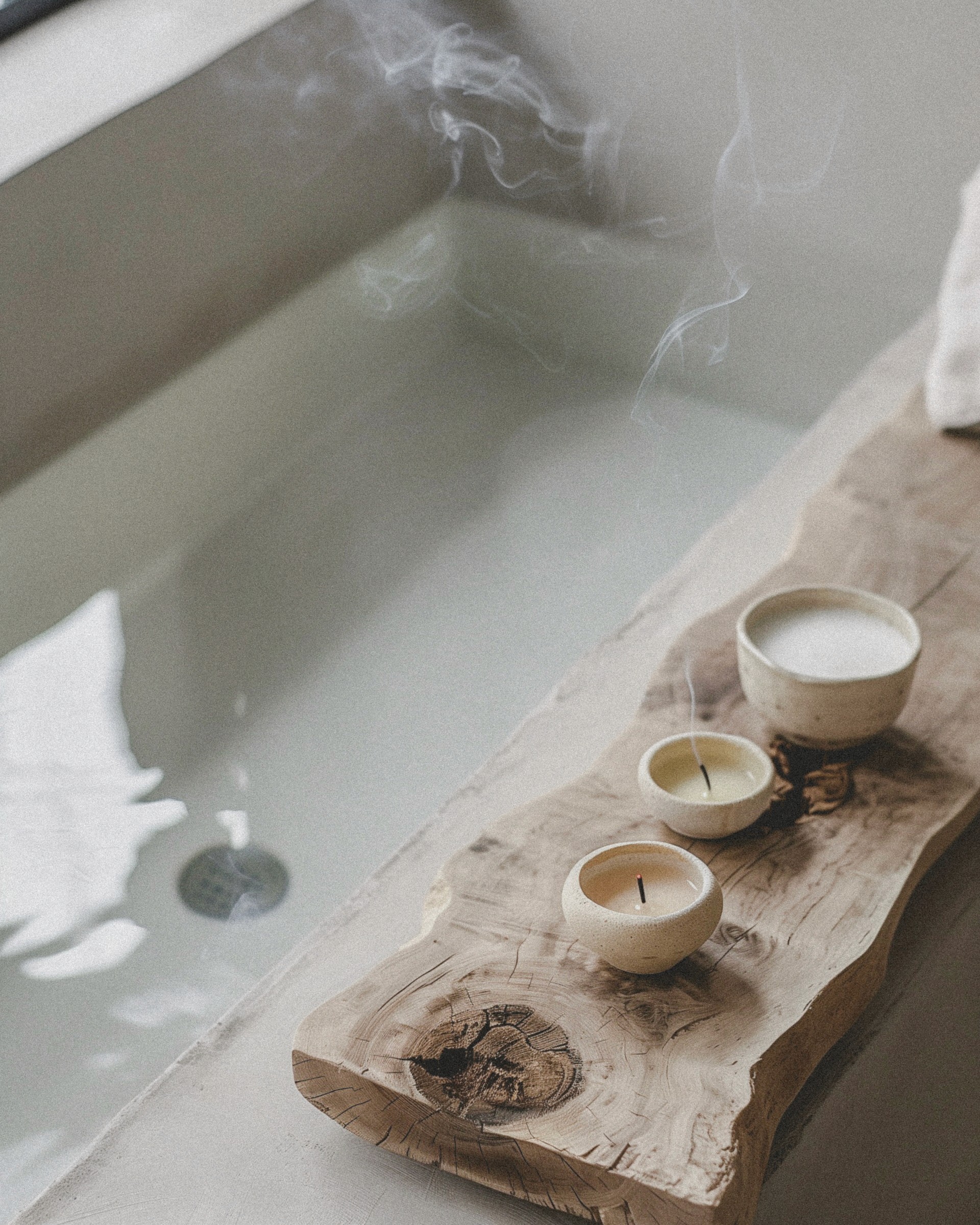 A bath with a candle resting on a wooden surface, creating a warm and calming ambiance.