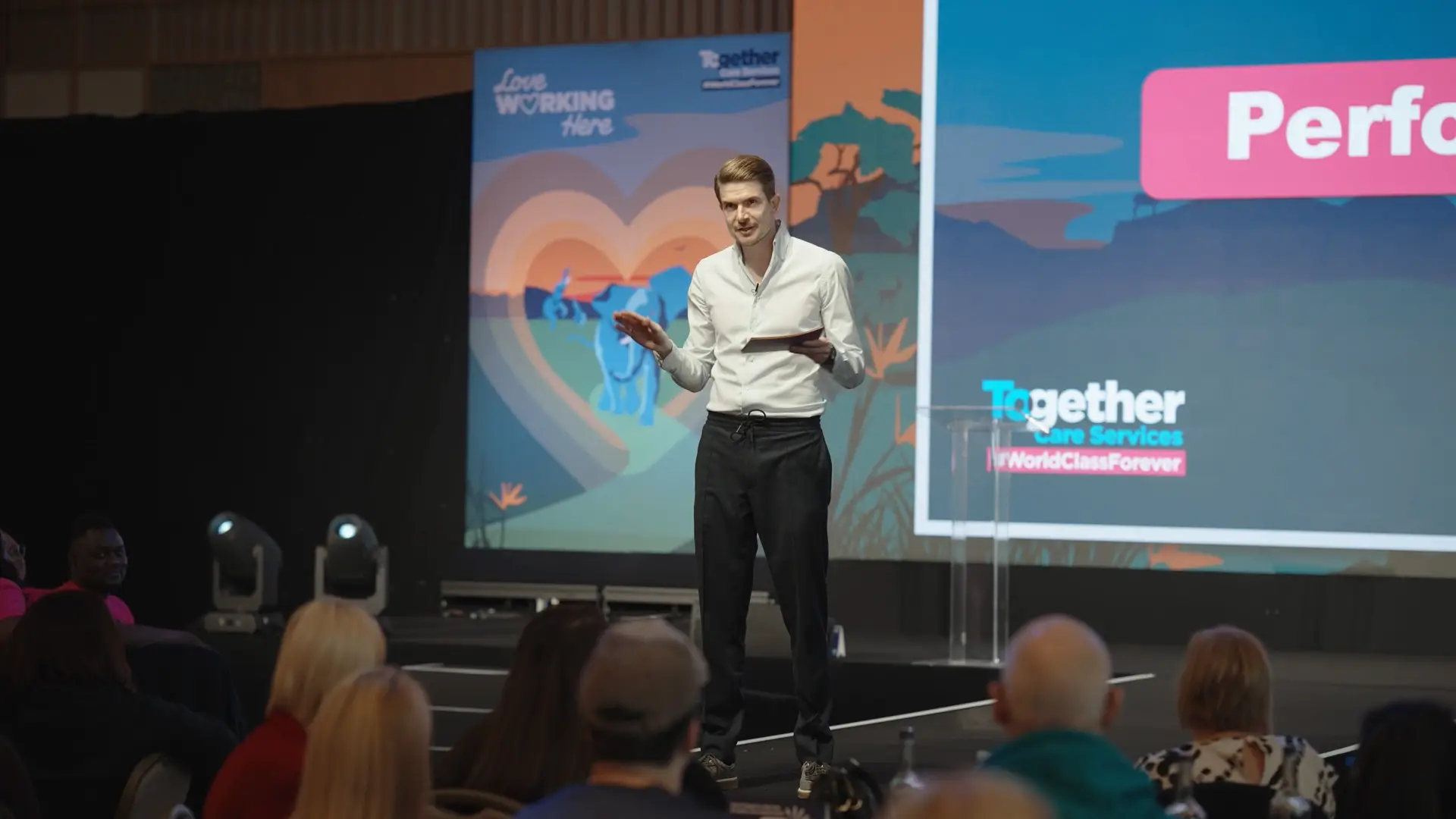 Bupa Care leadership presenter speaking on stage to care home managers at a national strategy event.