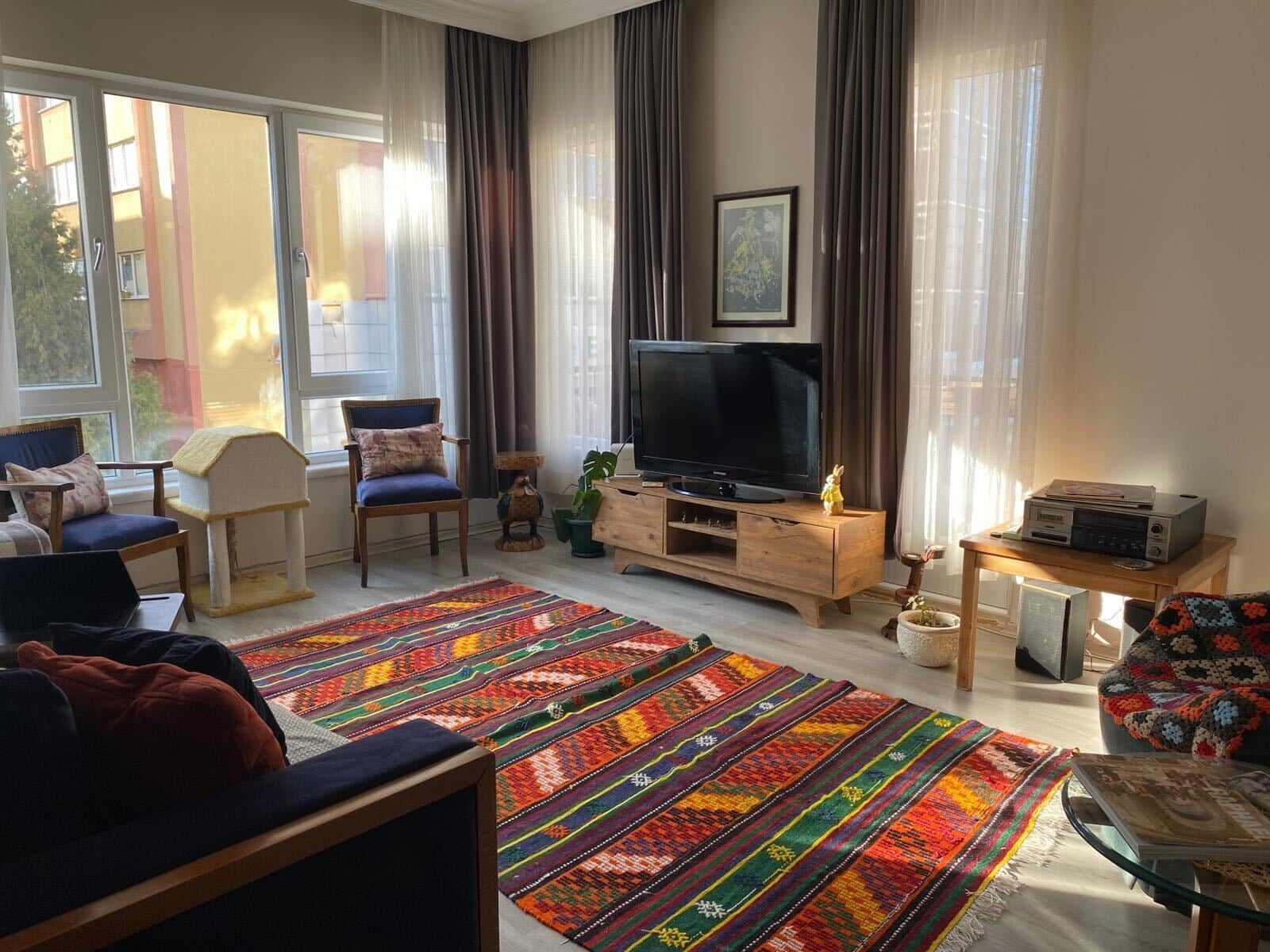 Living room before AI room design, kilim rug, blue sofa, floor-to-ceiling windows
