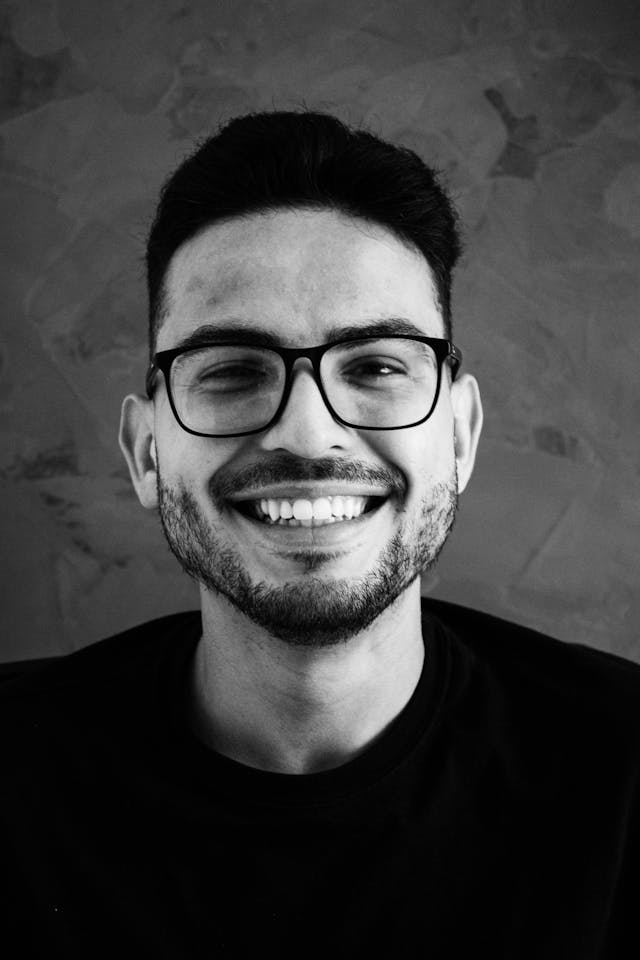Black and white portrait of a smiling person with curly hair