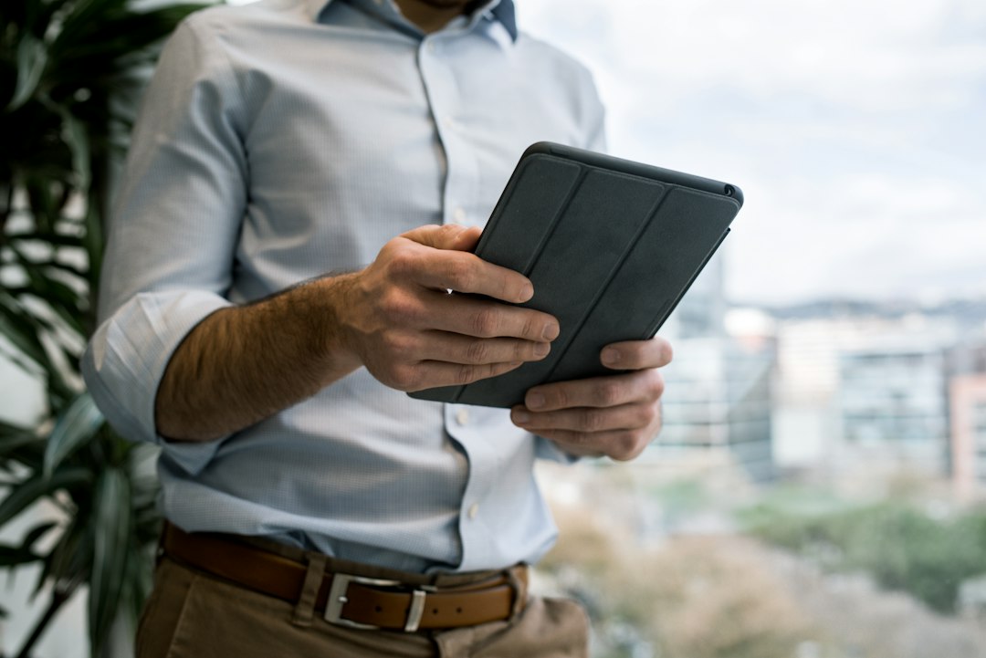 a tablet device showing financial graphs and balance sheets on a wooden desk, a stethoscope nearby, soft morning light