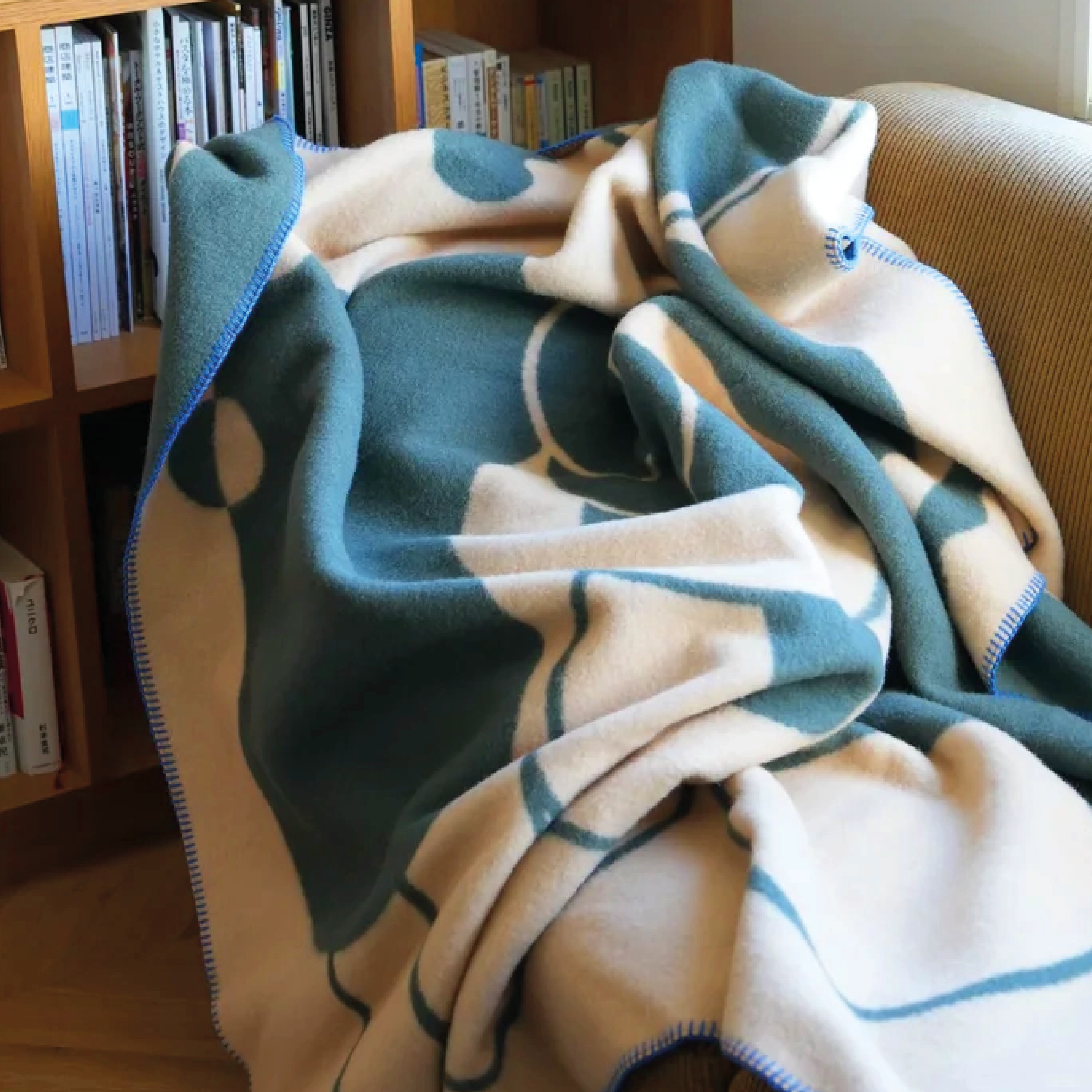 MY TONE blankets pattern displayed on a sofa in green and beige tones.