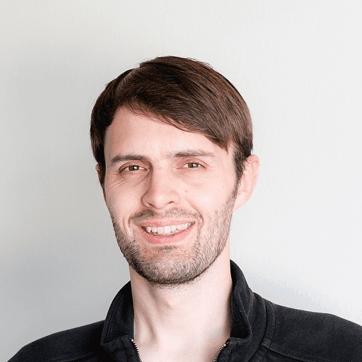 Black and white portrait of a smiling person with curly hair