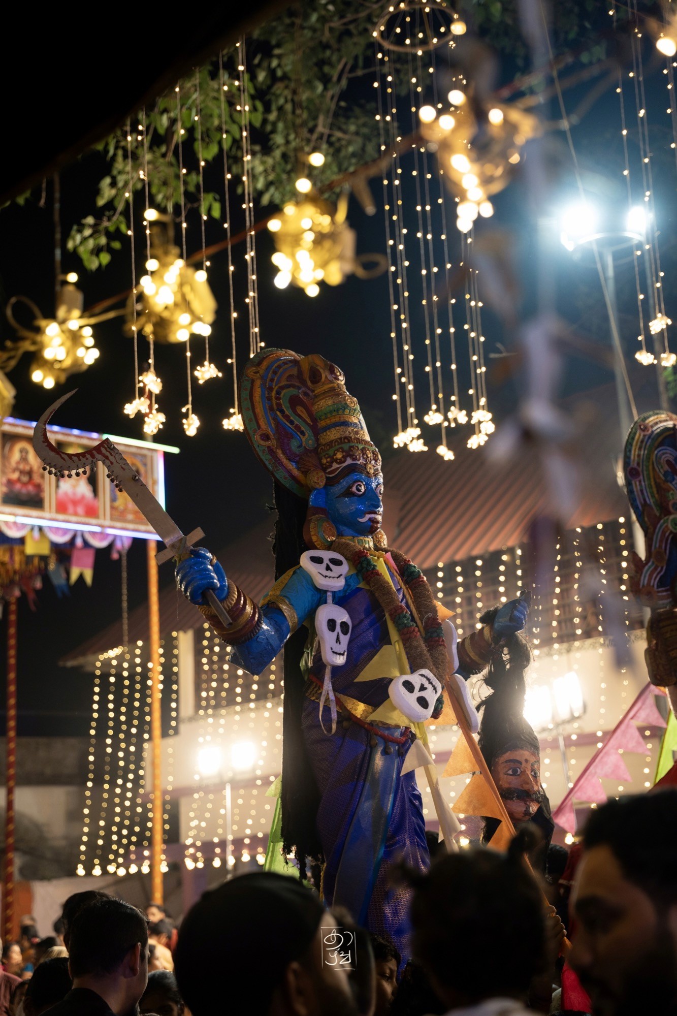 A Kali figure under a curtain of fairy lights