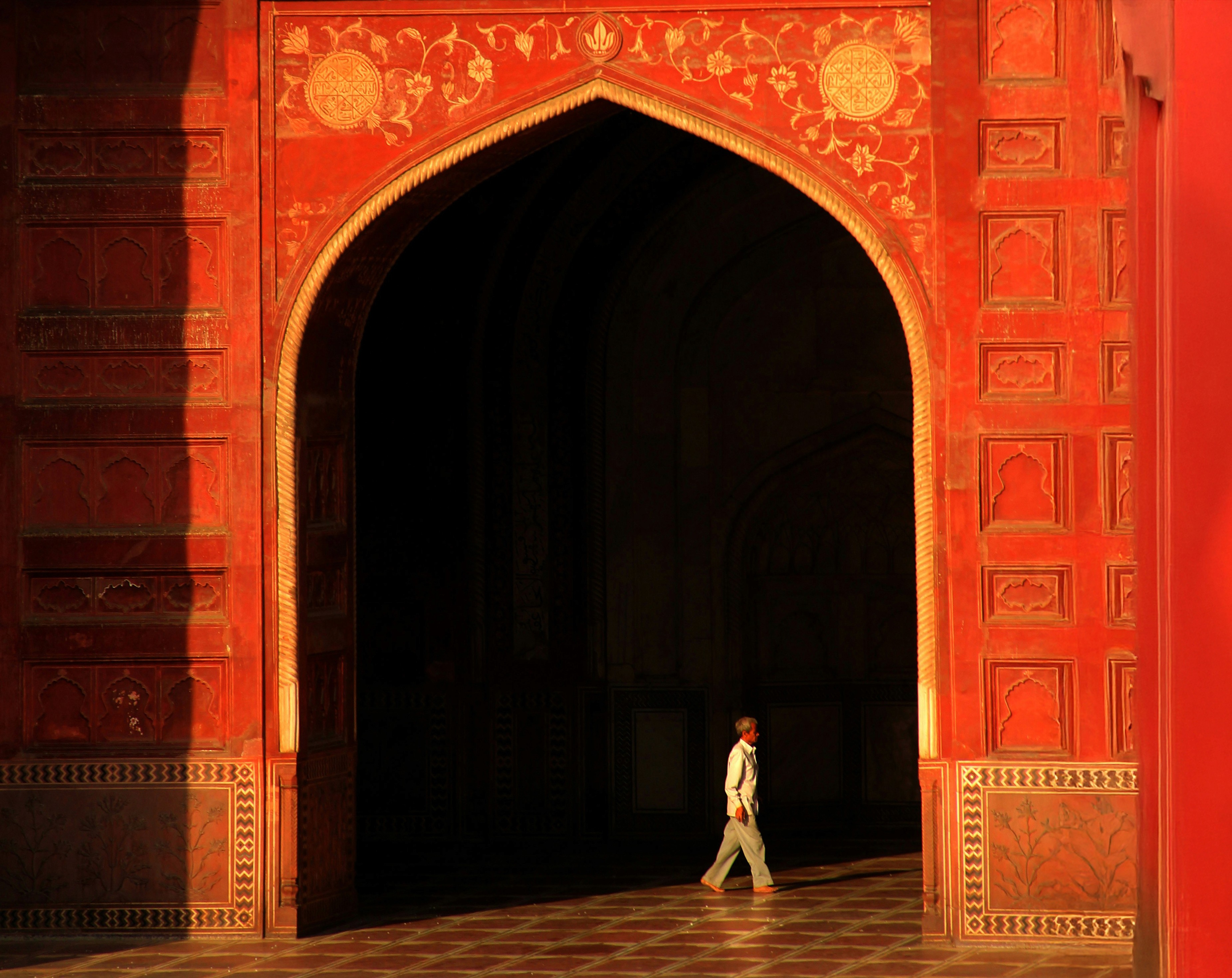 man in black suit standing near brown concrete building during daytime