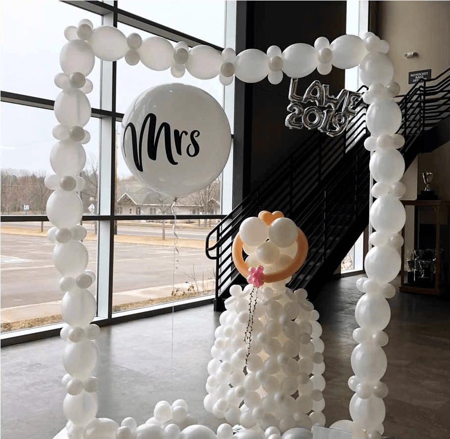 White balloon arch with a Mrs sign and a decorative bear figure designed by Be Bold Balloons for an indoor wedding display