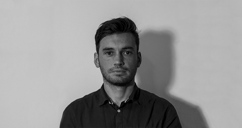 A black and white photo of a man wearing a shirt.