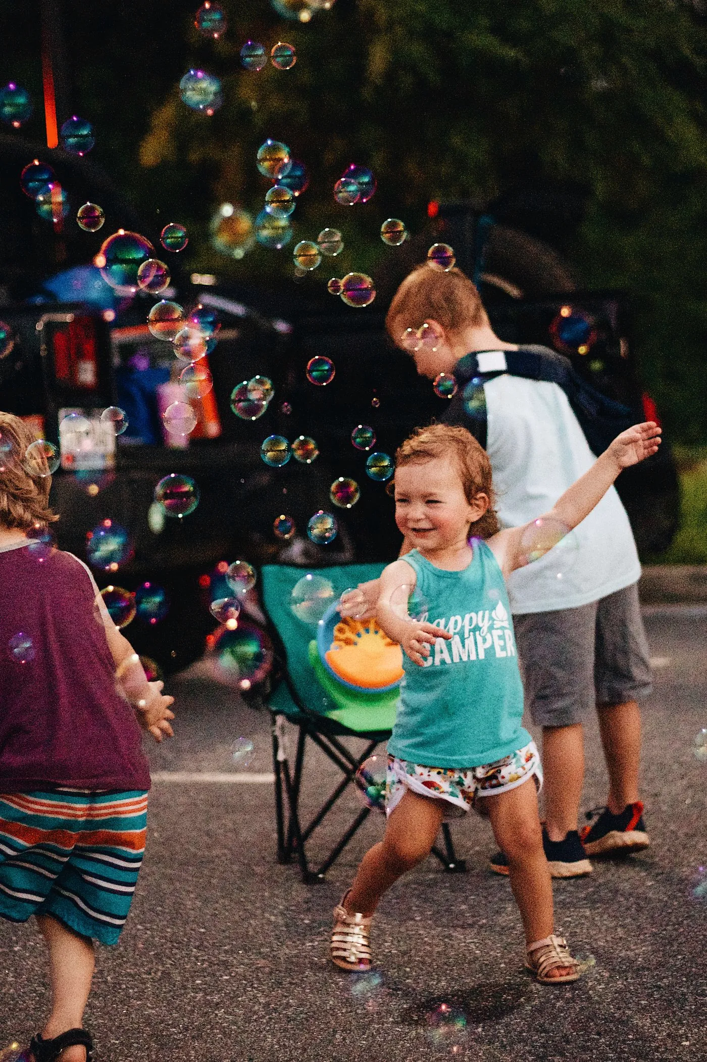 Kids laughing and chasing bubbles