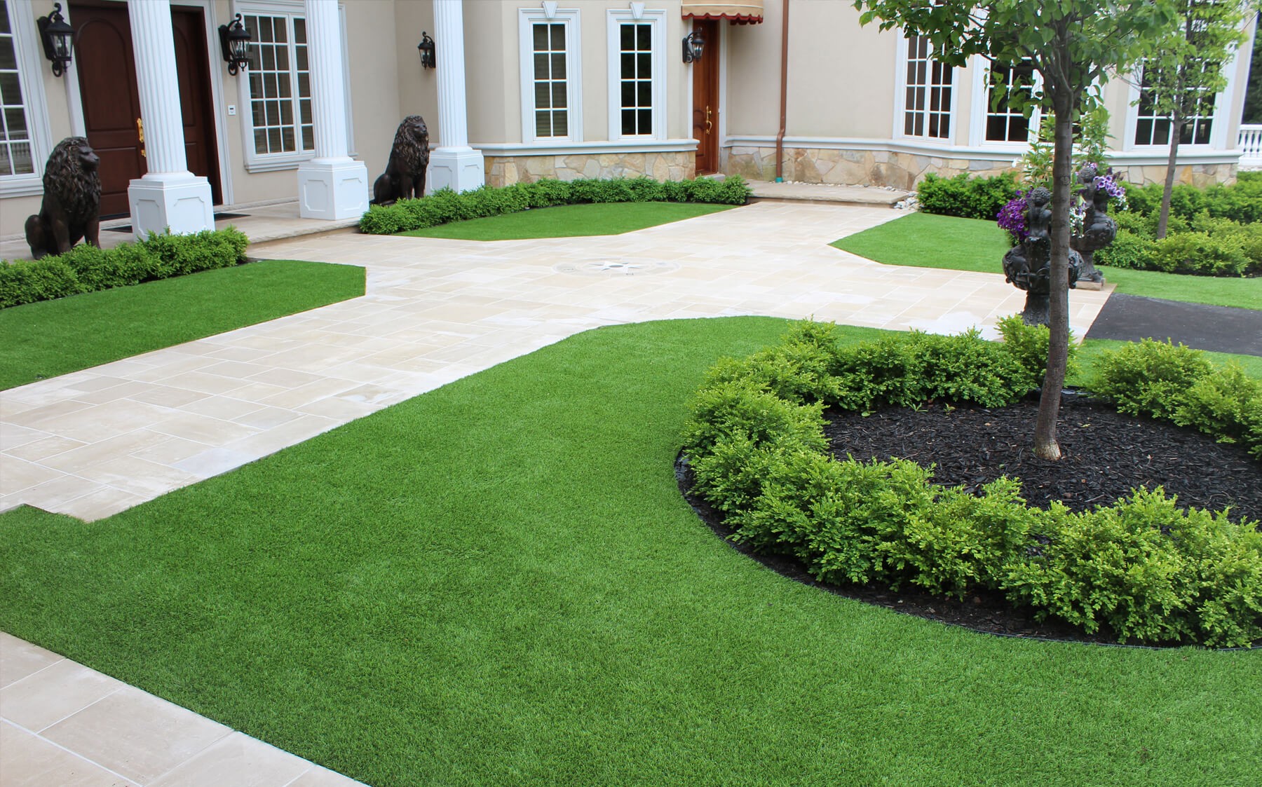 A neat synthetic lawn with decorative shrubs enhances the curb appeal of this lovely house.