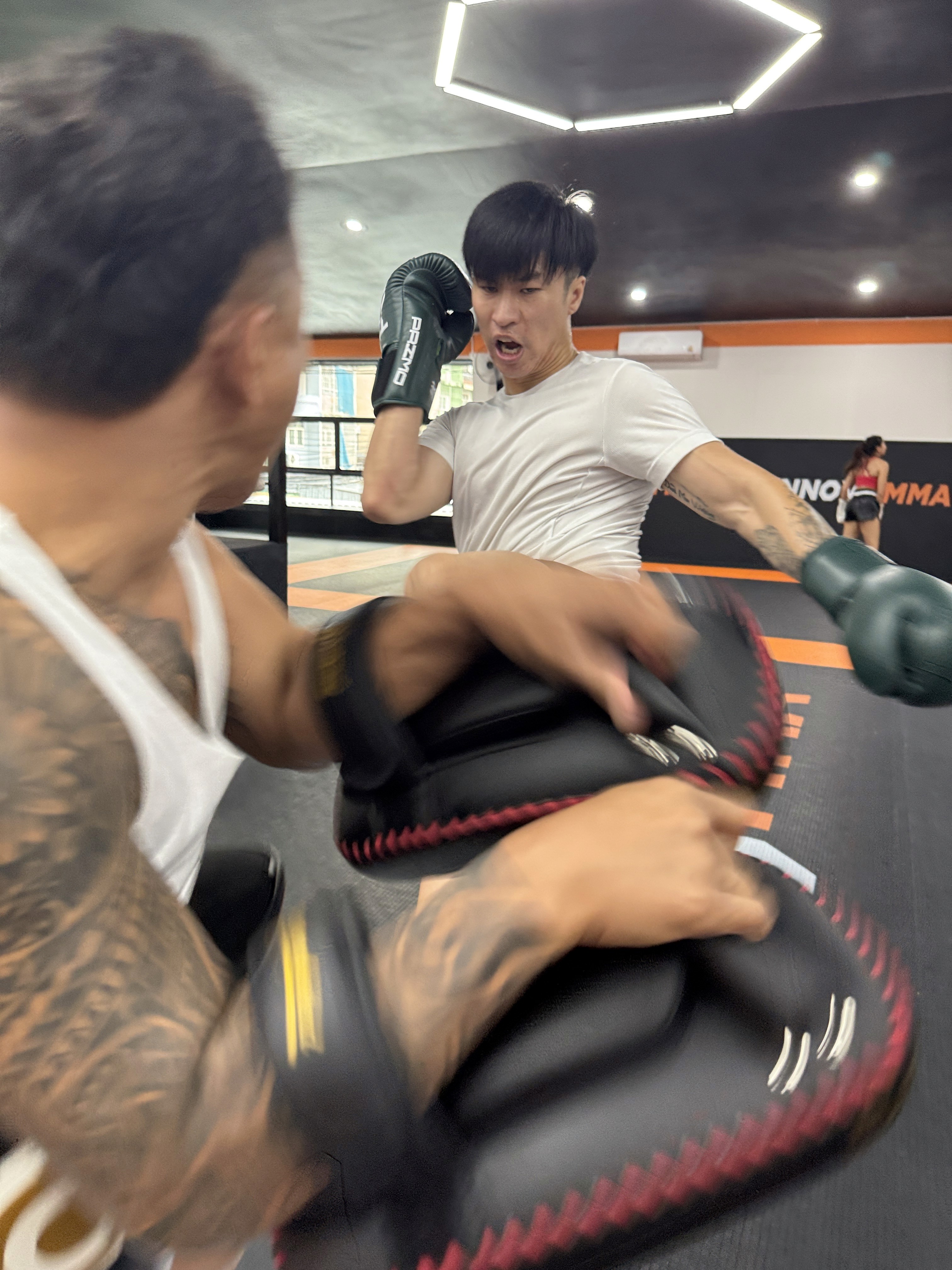 Man and trainer hitting poads at INNOV8 MMA Gym