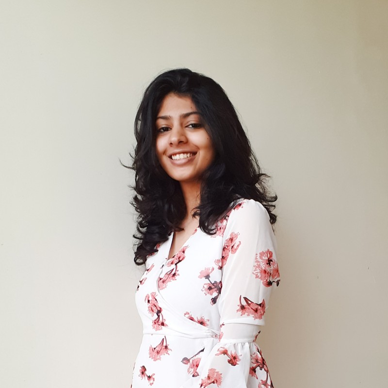 woman looking sideways leaning on white wall