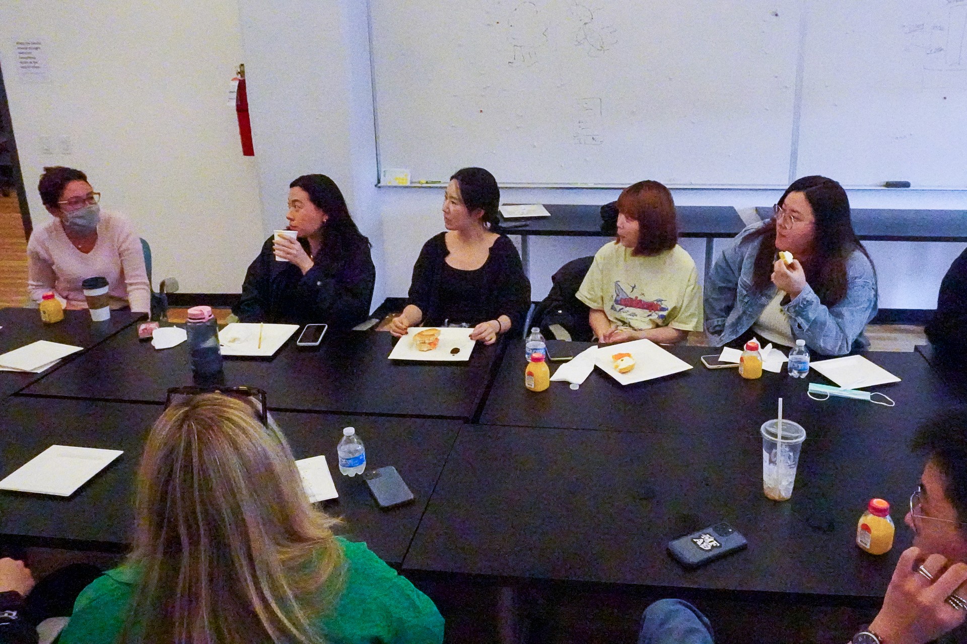 A photo of a group of people sitting at a conference table in an office room.