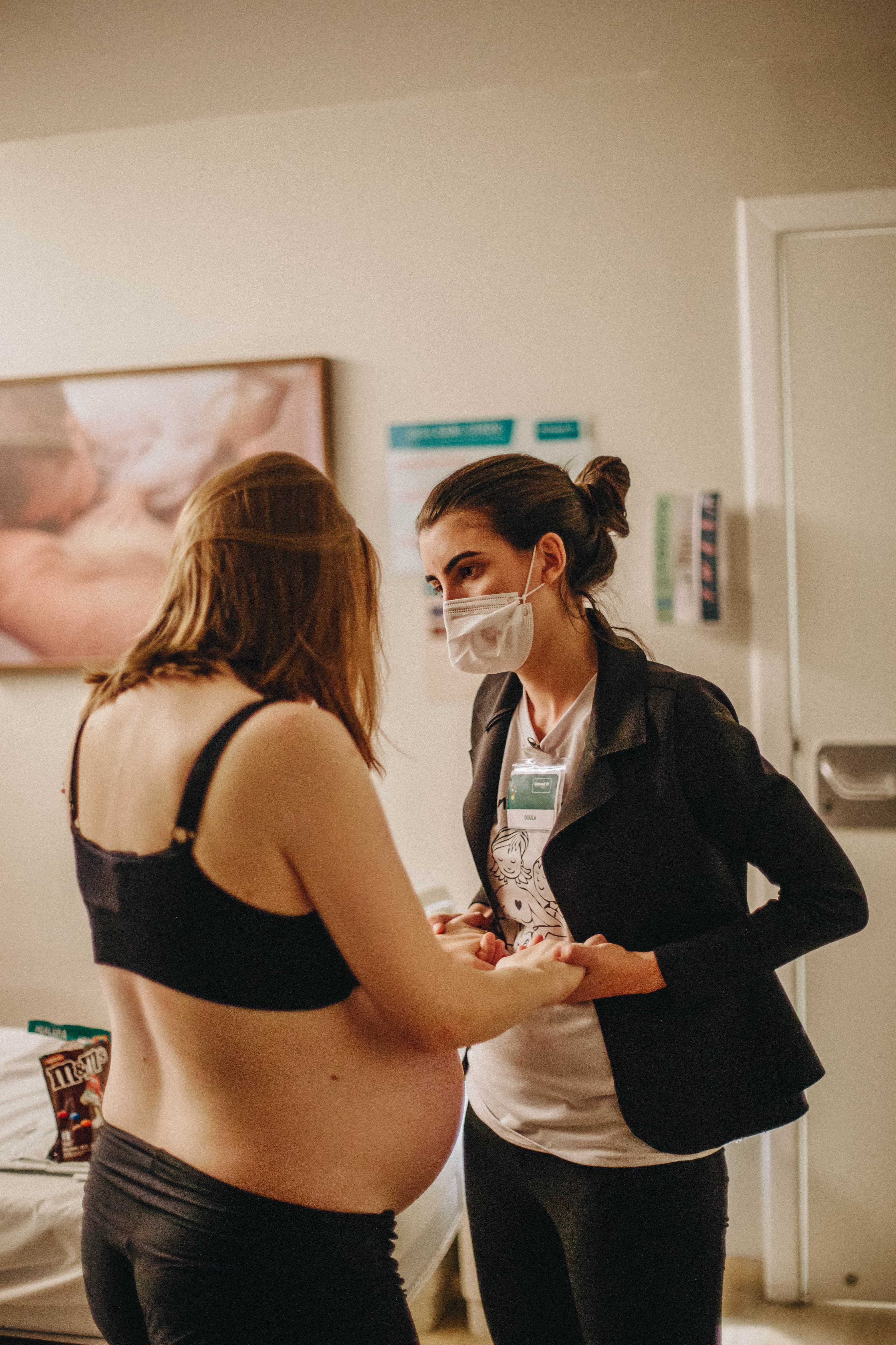 mulher segurando a mão de uma parturiente