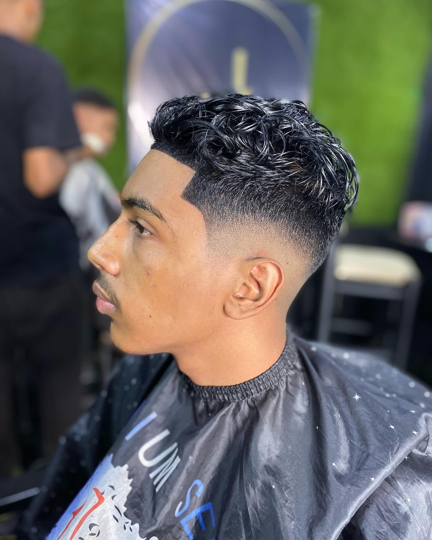 An Image of a person sitting in the Diamond Standard with a fade haircut