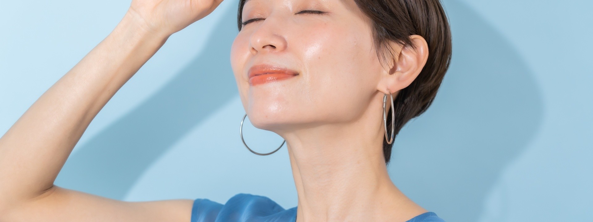 顔に手をかざす女性の横顔