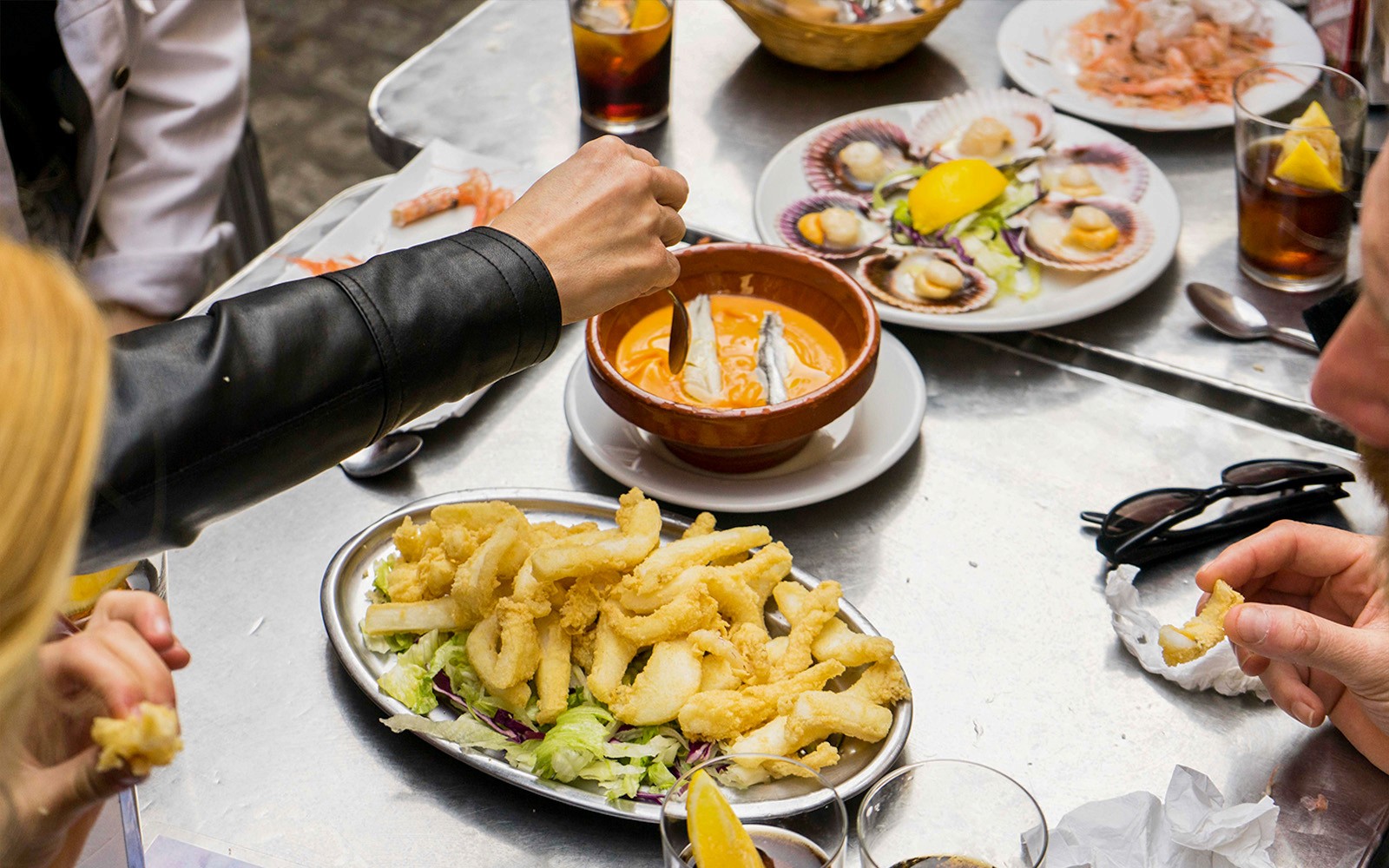 Participants enjoying seafood dishes on a Tapas Tasting Tour in Seville.