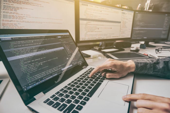 Web developer working on website hosting and maintenance on a computer