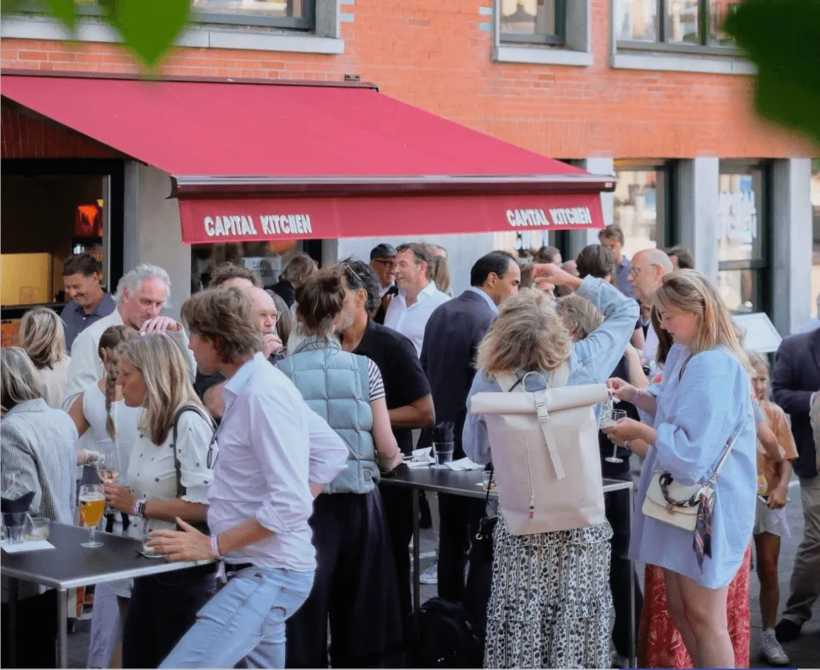 A bustling outdoor café scene with people socializing, sitting at tables, and enjoying the ambiance.