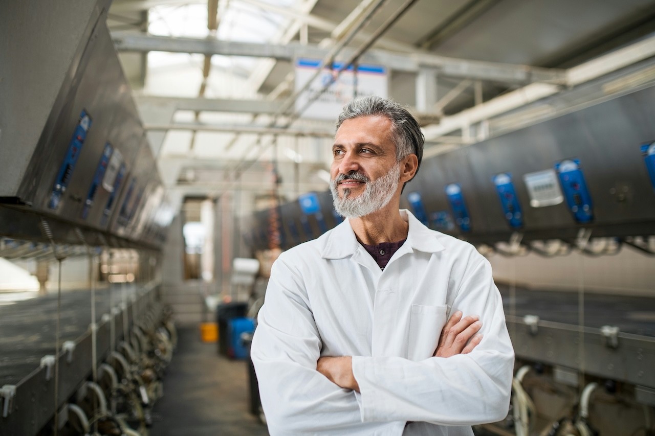 A SME Owner standing in his production facility smiling