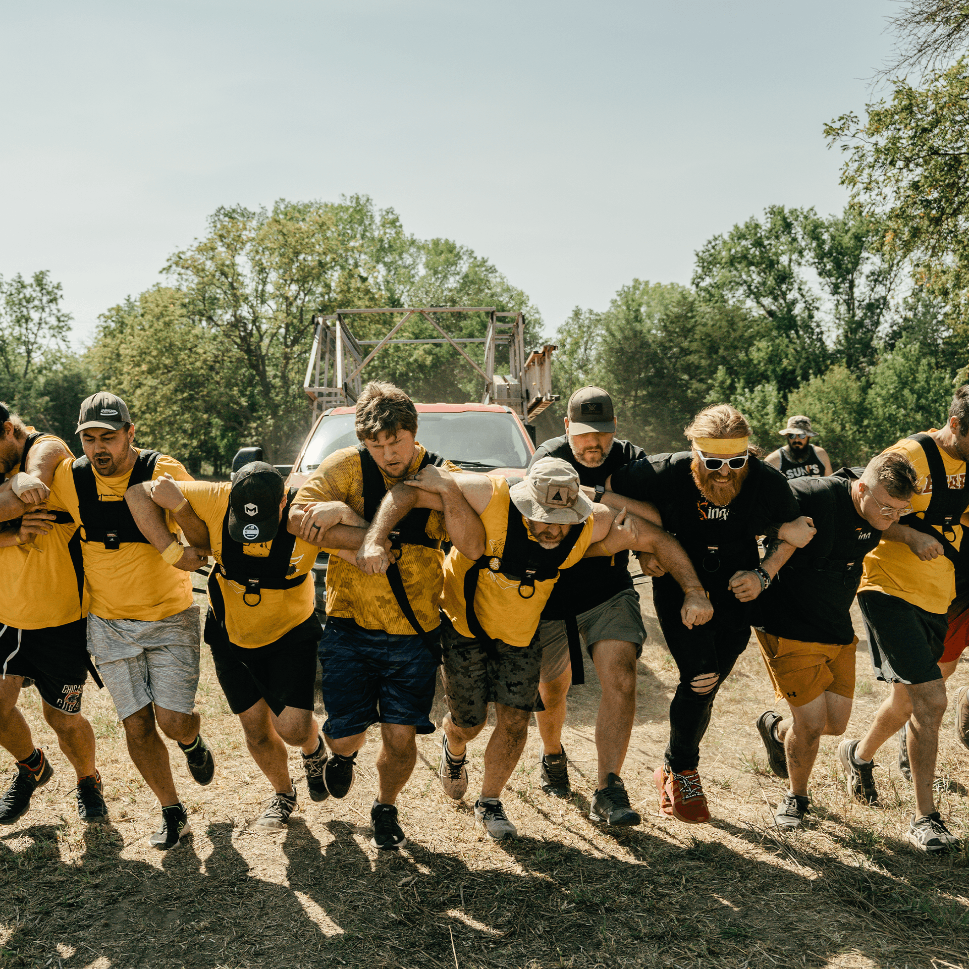 Men pulling a truck together.