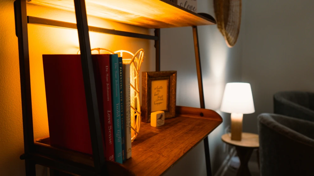 Bookshelf with therapy books and warm under-shelf lighting.