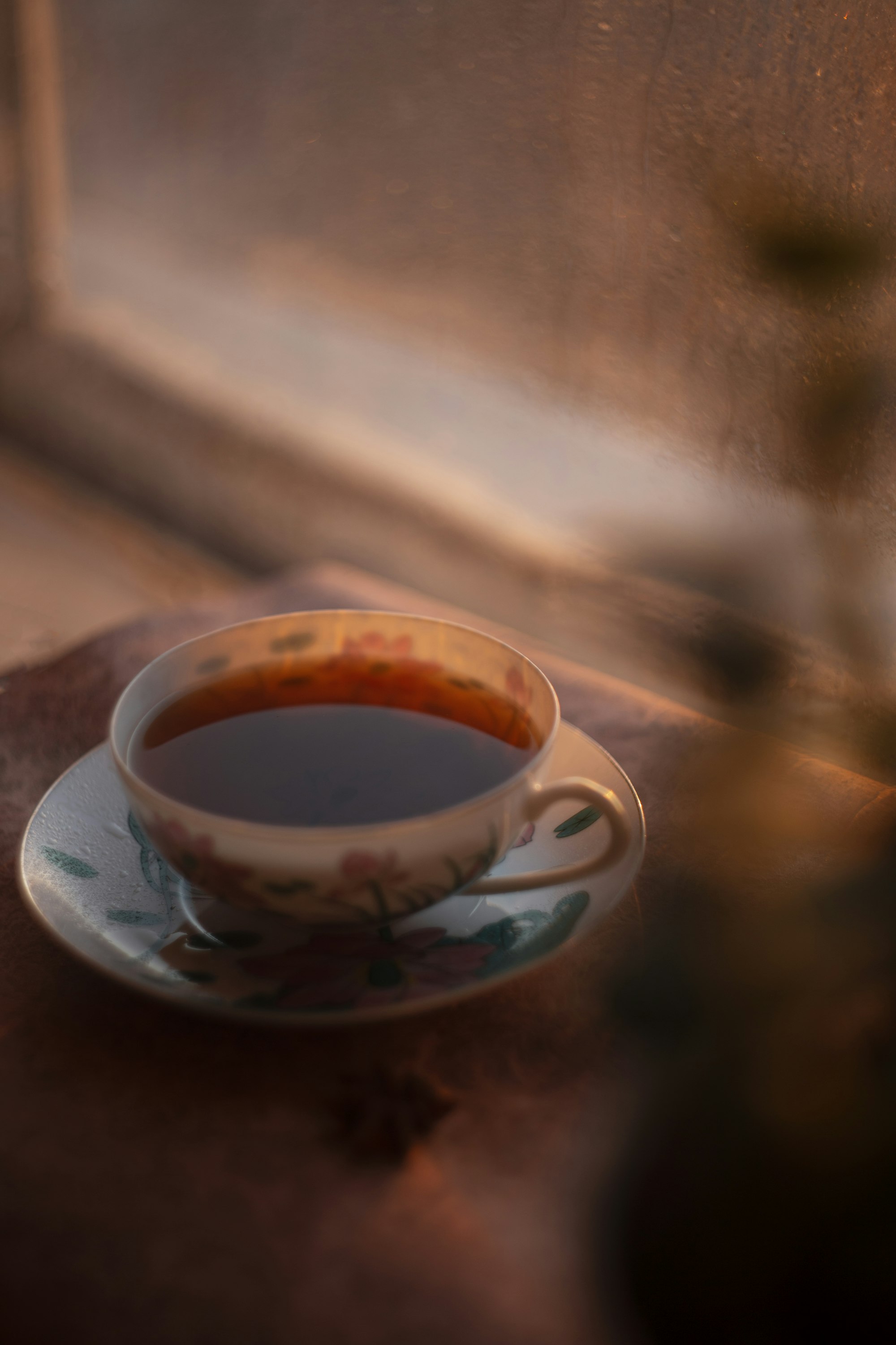 A cup of tea on a saucer in warm light