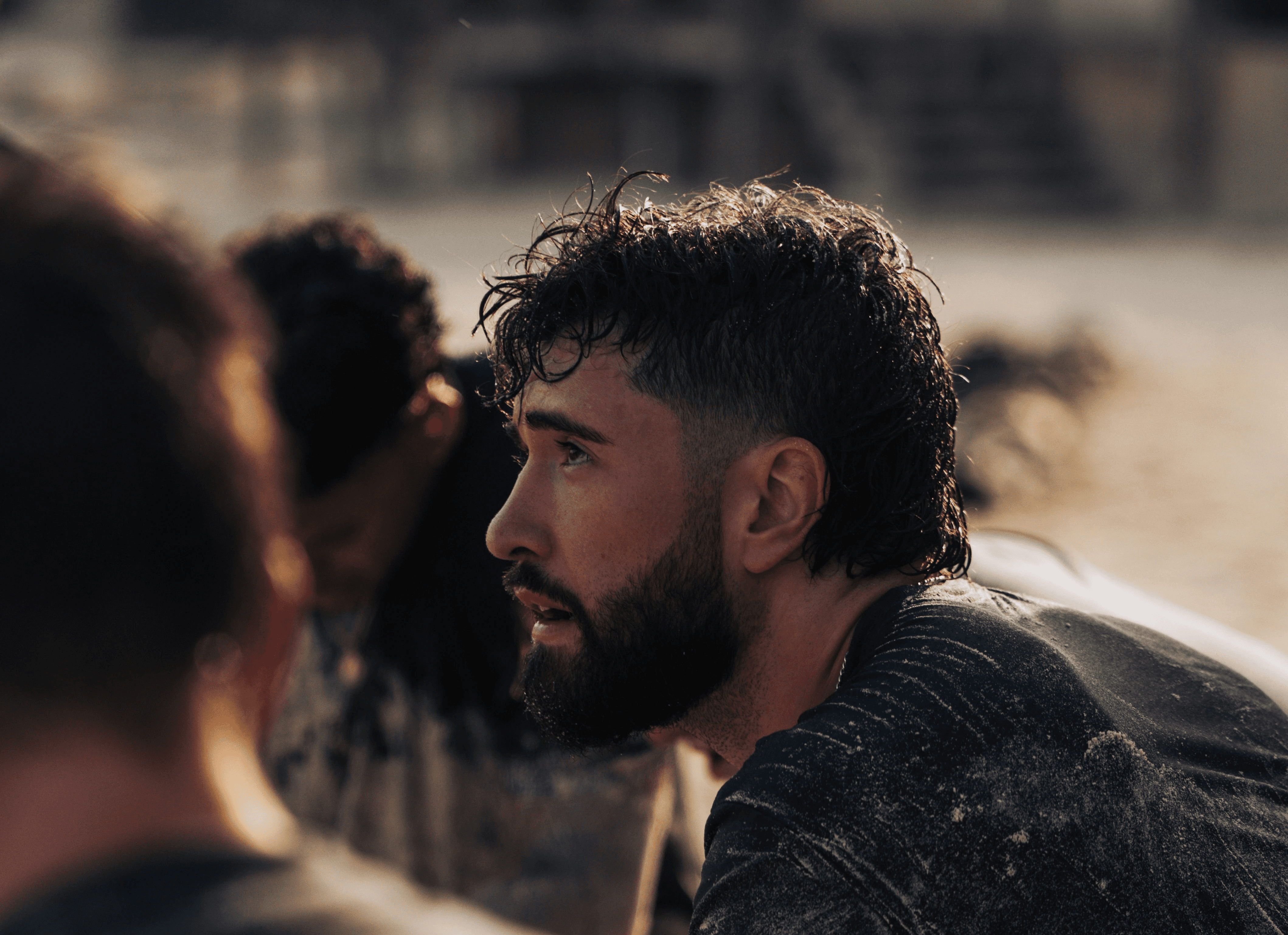 Man with beard and mullet in dirty shirt looking shirt.