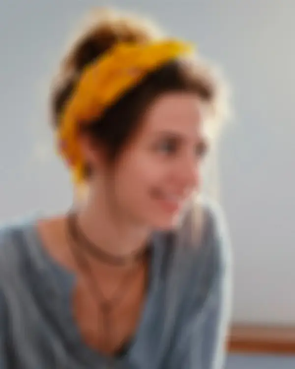 Záběr na usměvavé tváře lidí v přátelském rozhovoru, symbolizující lidský přístup, otevřenost a pozitivní energii týmu.