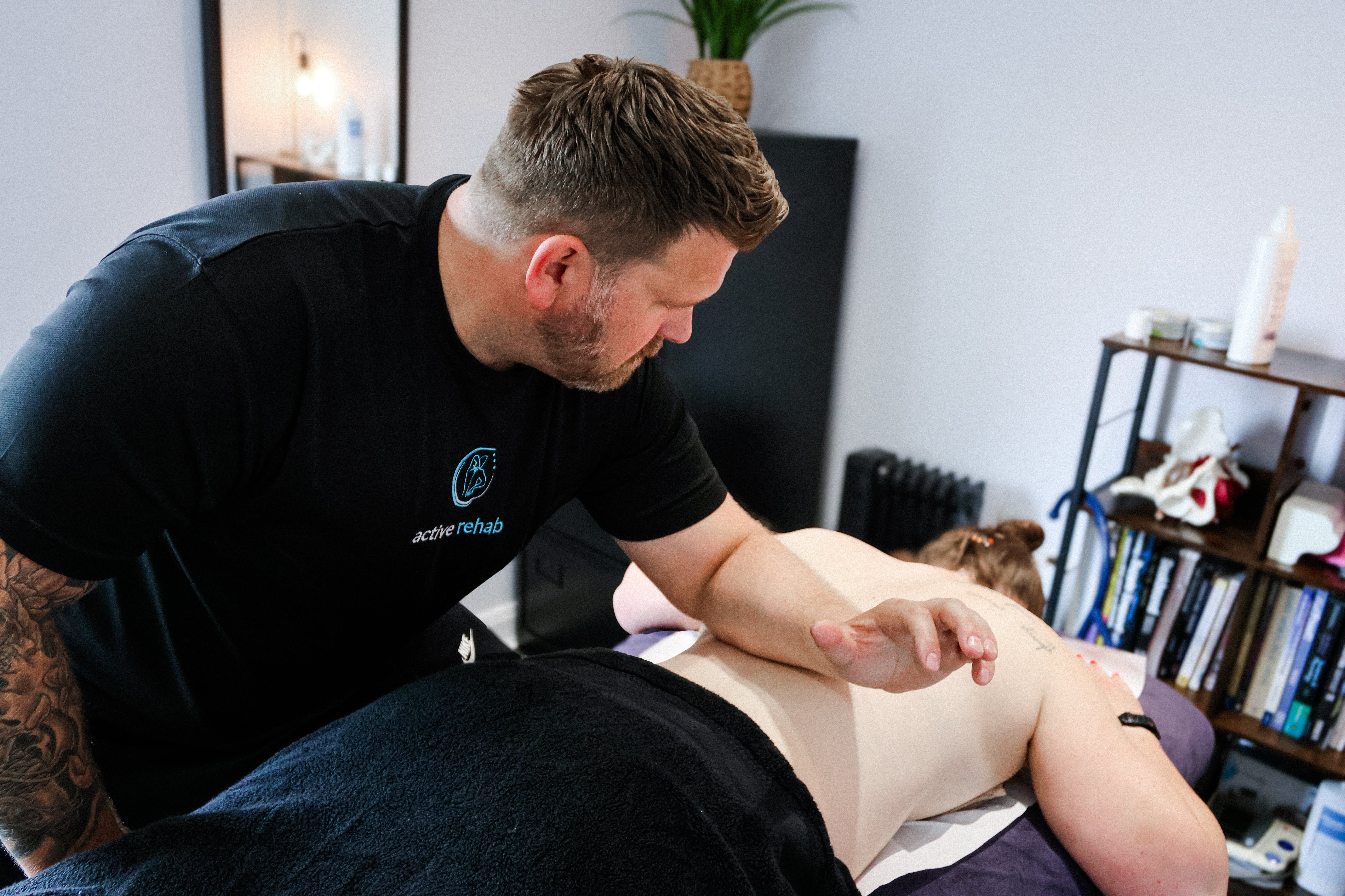 Sports therapist performing hands-on treatment on a client during a sports massage session at Active Rehab in Northern Ireland.