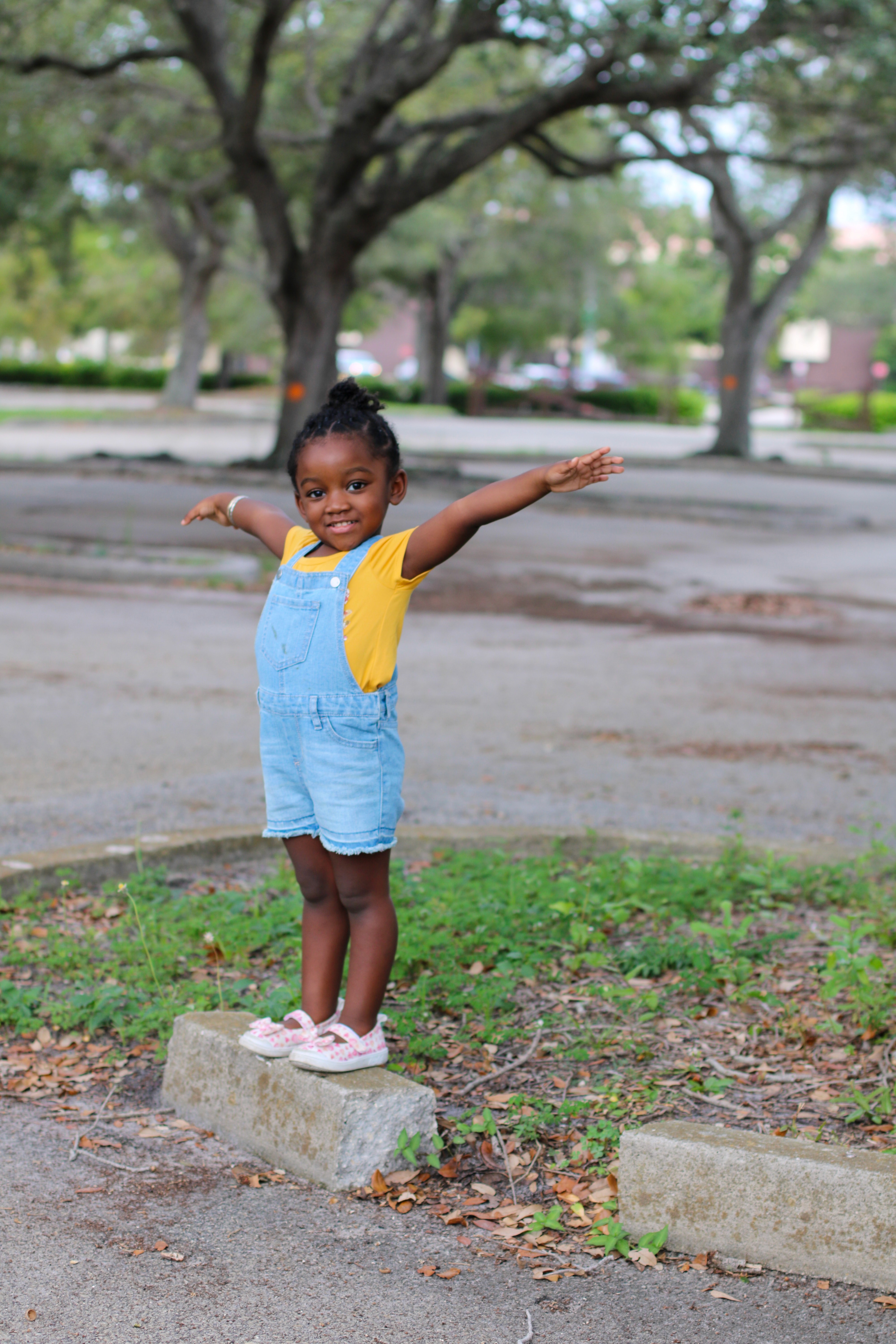 Une petite fille souriant les bras grand ouverts