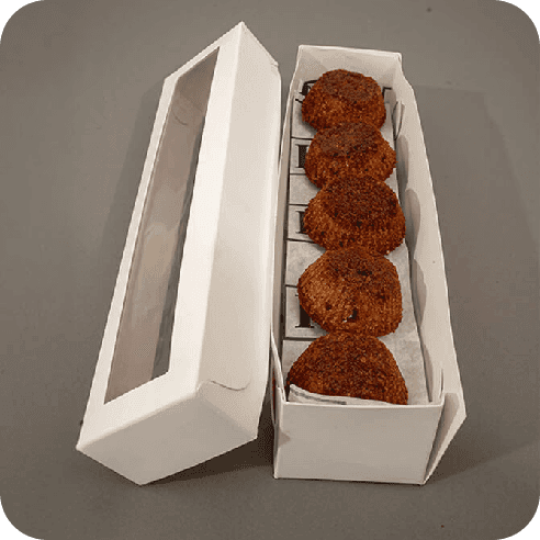 Caja blanca abierta con mini brownies artesanales de masa madre.