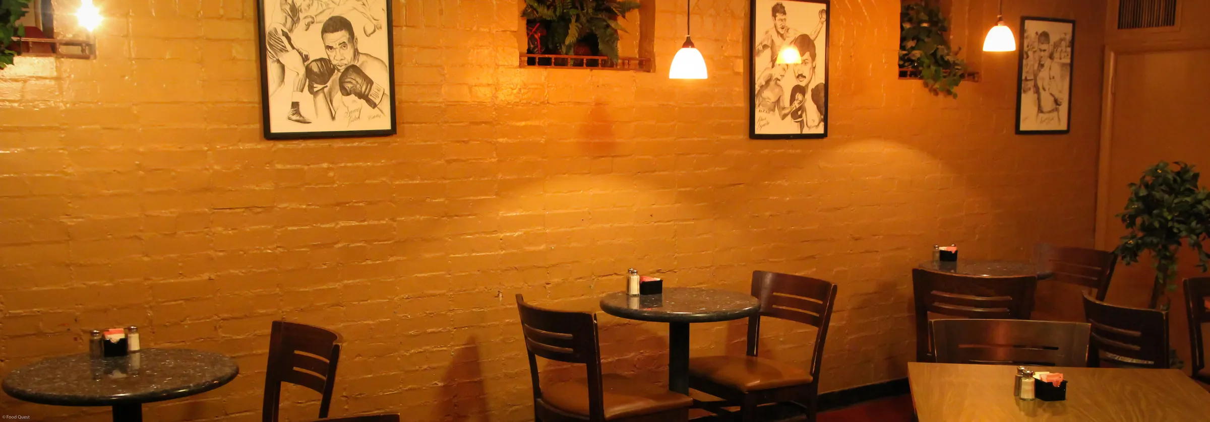 Dining tables under boxing sketches at Ringside Café