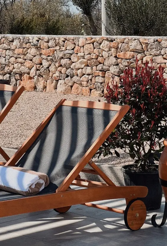 Drvene ležaljke u vrtu kampa Dvije Suze uz suhozid i mediteransko bilje