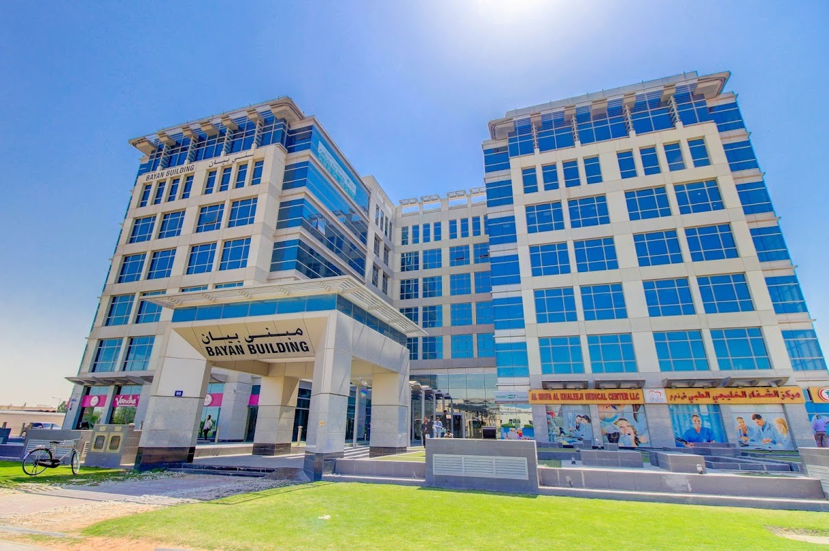 Exterior view of Bayan Building showing retail spaces and medical clinics in a high-traffic business hub.
