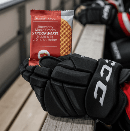 Maple Terroir Strawberry Maple Cream Stroopwafel resting on hockey gloves, close-up product lifestyle shot.