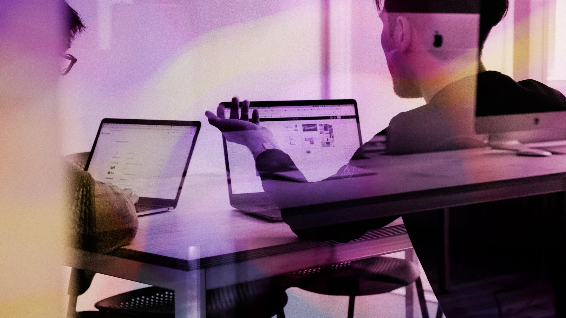 A person gestures at their laptop while making a point