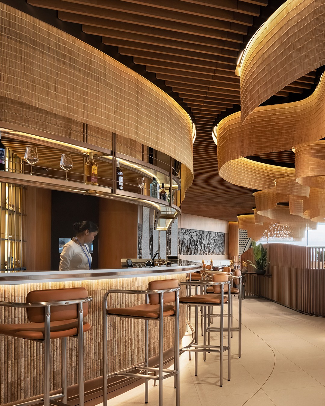 malis-restaurant-kti-interior-design Warm lighting and wooden slat ceilings in the Malis Restaurant dining area at Techo International Airport.