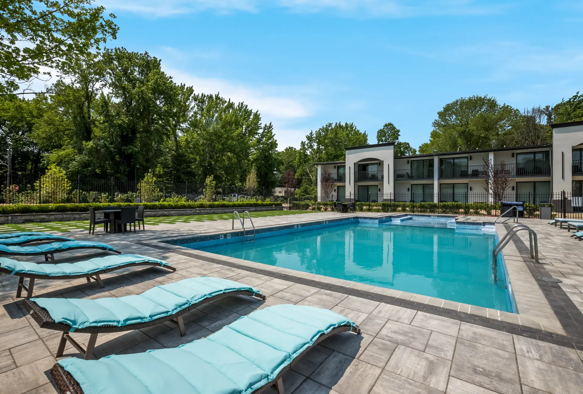 Swimming pool with lounge chairs on patio area.